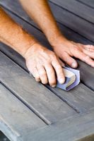 Sanding wooden table in prepartion for treating with oil