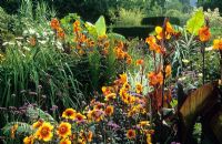 The exotic garden at Great Dixter. Planting includes Dahlia 'Moonfire', Canna 'Wyoming', Musa basjoo and Verbena bonariensis.