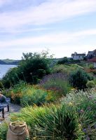 Seaside garden with Phormium, Lavandula, Crocosmia and Euphorbia characias - Dawlish