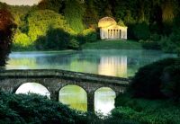 Early morning with bridge over lake and The Temple Pavilion on the far side reflected in the water - Stourhead, Stourton, Wilts 