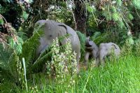 Stone Elephants as garden ornaments in a woodland setting