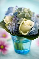 Small bouquet of Hydrangea, Roses and Muscari in blue glass vase