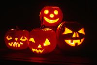 Four pumpkin lanterns for Halloween lit with tea-lights