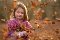 Little girl holding Autumn leaves