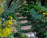 Mosaic fish patterned stepping stones with Ophiopogon 