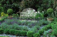 White iron seat and lavender maze with slate paths and box balls