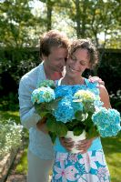 Happy couple holding pot with Hydrangea