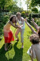 Family playing with hose in garden 