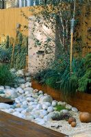 Roof garden with bamboo fencing,  white boulders, barleycorn gravel, red cedar decking and water feature
