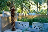 View across garden with low level wall enscribed with arabic writing - His Highness Shaikh Zayed Bin Sultan al-Nahyan
Garden from the Desert, Chelsea 2003 