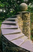 Curved stone wall with slate top and sphere
