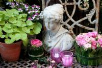 Arrangement with pink roses, candles and statue