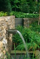 Lip waterfall in retaining wall with steps and Hostas in background - The Odrich Garden, Greenwich, Connecticut, USA