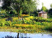 Country garden with pond and pavillon in background