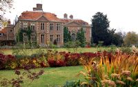 View of South facade of Heale House with Croquet Lawn, Musk Rosa border underplanted with Sedum 'Autumn Joy'