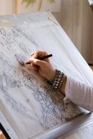 Woman working on garden design at drawing board