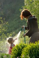 Woman and small child watering garden