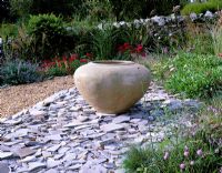 Broken slate border with large urn in Devon garden