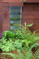 Water feature on panelled wall planted with shade loving plants - Formal Elements Garden, RHS Hampton Court Flower Show 2008