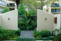 Cream painted dividing walls and symmetrical tropical planting, bird box on wall - Auckland, New Zealand