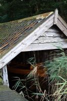 Rustic boathouse with wooden boat, surrounded by Norfolk Reeds