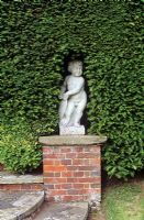Statue of a boy in Yew hedge - Jenkyn Place Gardens, Hampshire