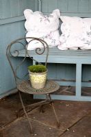 Summerhouse interior with old ornamental  chair and glazed pot of Mind-your-own-business 