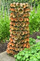 Bottle rack used to hang clay pots in private garden, Hampshire.