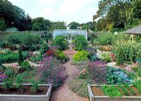 Overview of walled garden, with greenhouse, raised oak beds, planted with vegetables and flowers - The walled garden at Haddon Lake House