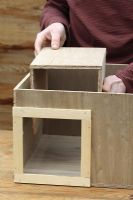 Step by step 5 of making a hedgehog house - Placing entrance tunnel, also made from plywood into wooden box