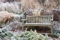 Wooden bench with prairie planting in winter