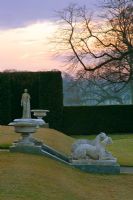 Urns, greyhound statues and yew hedging at dawn in winter - Brodsworth Hall, Yorkshire