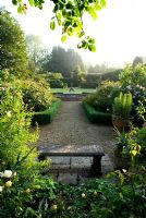 View into the rose garden to the water lily pool with heron sculpture - Mariners Garden, Berkshire