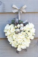 White rose heart wreath with speckled eggs tied to wall