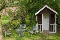 Wooden wendyhouse with childrens table and chairs - Poulton Hall, NGS garden, Cheshire