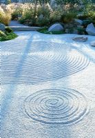 Japanese inspired garden for the offices of a Pharmaceutical company, Boston. Patterns have been raked into the gravel, planted with grasses and stone bridge