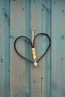 Heart shape made out of twigs hanging on a shed door at RHS Harlow Carr, England