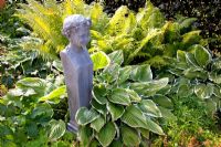 Statue placed in shadey border with Hosta and Matteuccia struthiopteris - Fern
