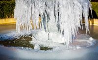 Frozen ornate water fountain in winter at Wilkins Pleck NGS, Whitmore, Staffordshire