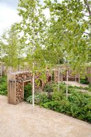 Narratives of Nature garden with log wall and moon gate. Planting includes ferns, Geranium sylvaticum, Luzula nivea, Atriplex hortensis, Umbilicus rupestris and Betula pubescens - Future gardens, St Albans, Herts 