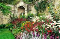 Border above the croquet lawn of Cosmos 'Gazebo mixed', Crocosmia 'Lucifer', Stachys byzanmtia, Rudbeckia, Gladioli, Heuchera, Persicaria - Dewstow Gardens and Grottoes, Caewent, Monmouthshire, Wales