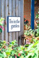 Hand stencilled sign hanging on wooden gate
