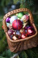 Christmas decorations in wicker basket and pine tree