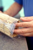 Making a lacewing shelter - Inserting an old bamboo table mat into a bottle