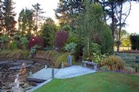 Pond with jetty surrounded by trees and shrubs - Breedenbroek, New Zealand