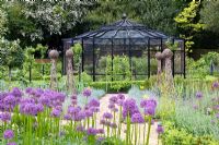 Potager with fruit cage, obelisks and Alliums in foreground