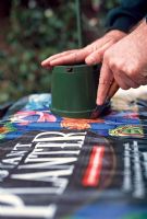 Planting Tomato plants. Use a knife to cut planting holes in the skin of the grow bag and remove the plastic discs