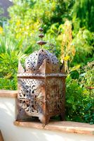 Moroccan pierced ironwork candle lantern on wall