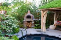 Clay oven next to a plunge pool and covered seating area with green roof. Viburnum. The Children's Society garden, Gold medal winner, RHS Chelsea Flower Show 2010 
 