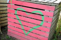 Colourful compost bin with a heart painted on the front